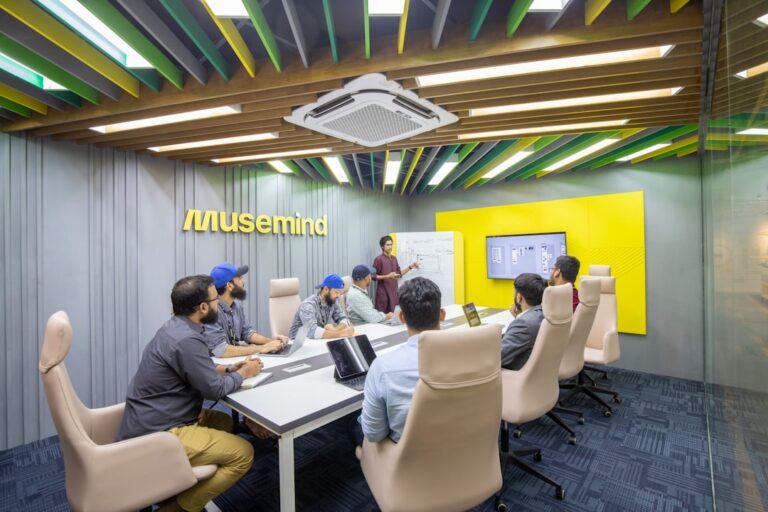 Team meeting in Musemind office; employees collaborating around a table.