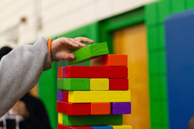 Child's hands building a colorful block tower.